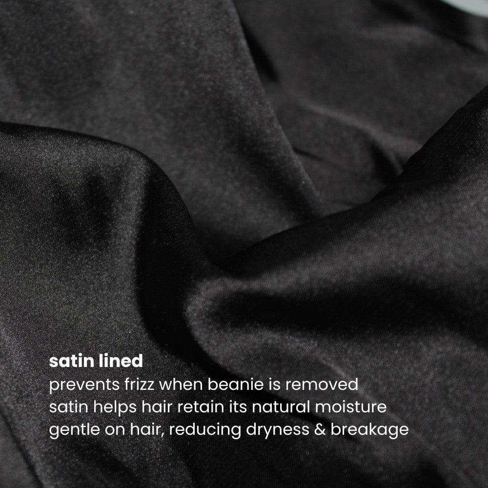 Close-up of the satin lining inside the Miae Black Satin-Lined Beanie, with text highlighting its benefits: reducing frizz, retaining moisture, and gently protecting natural, textured, and curly hair.