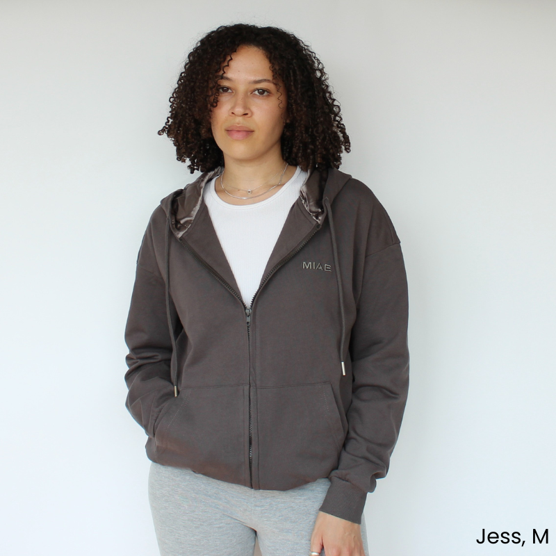 Model wearing the Miae Charcoal Satin-Lined Zip Hoodie, combining a relaxed fit with curl-protecting satin lining