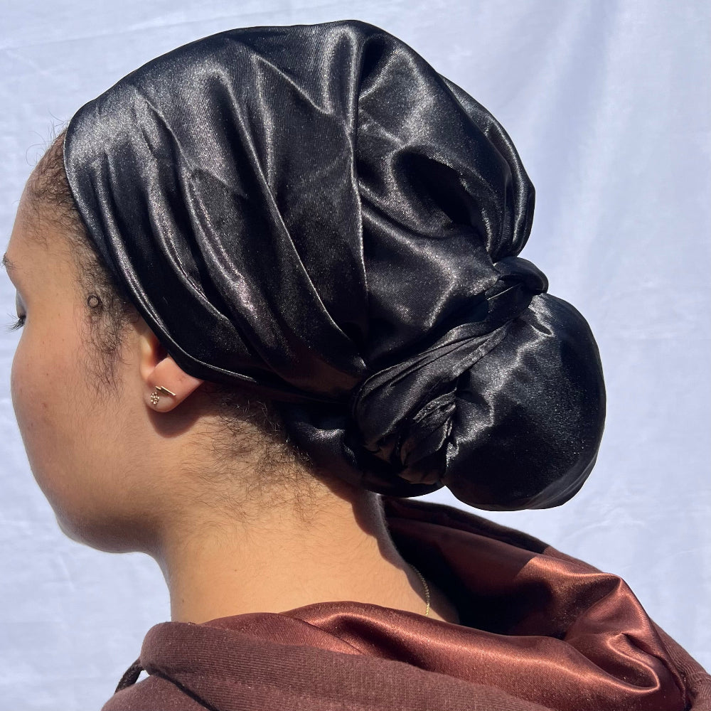 Curly hair styled with the Miae Black Satin Hair Scarf, offering a gentle, frizz-free hold while maintaining hair moisture.