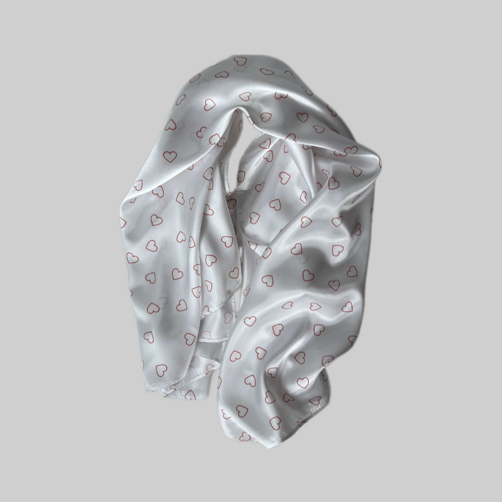 Flat lay of the Miae Satin Hair Scarf with minimalist love hearts, offering a smooth, frizz-reducing style for textured hair