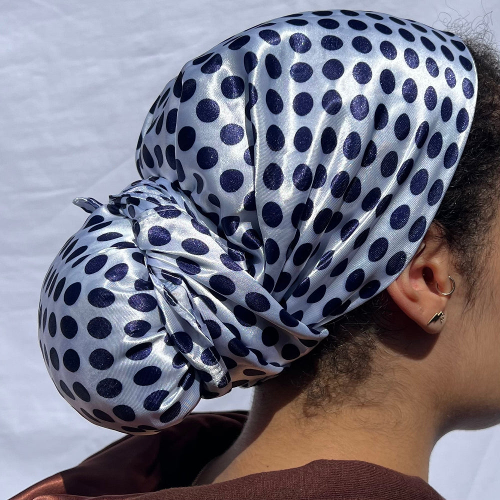 Model wearing the Miae White Satin Hair Scarf with blue polka dots, styled over curly hair to prevent frizz and retain moisture.
