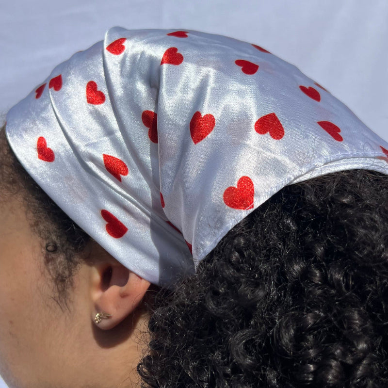 Alternative angle of curly hair styled with the Miae White Satin Hair Scarf featuring red love hearts, gently protecting hair while preventing frizz.
