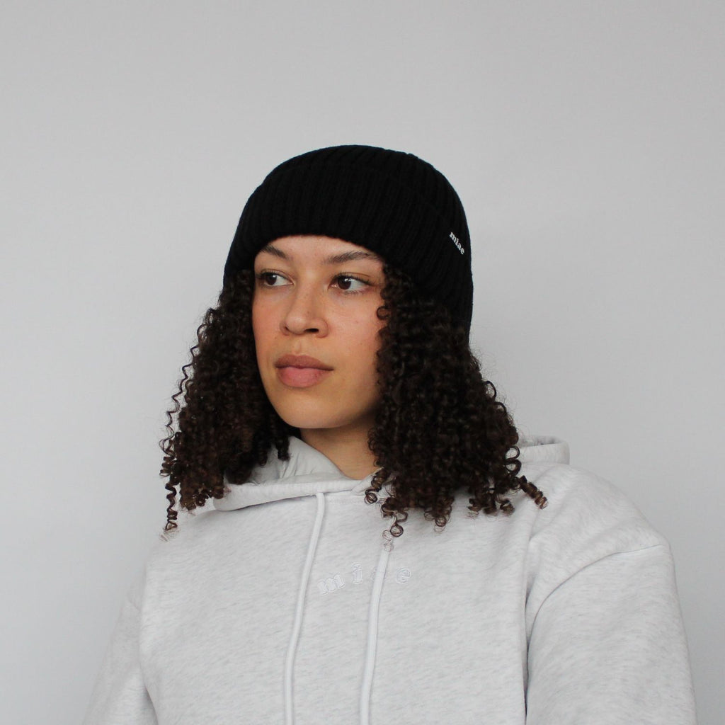 Model wearing the Miae Black Satin-Lined Beanie, designed to protect natural, textured, and curly hair while preventing frizz