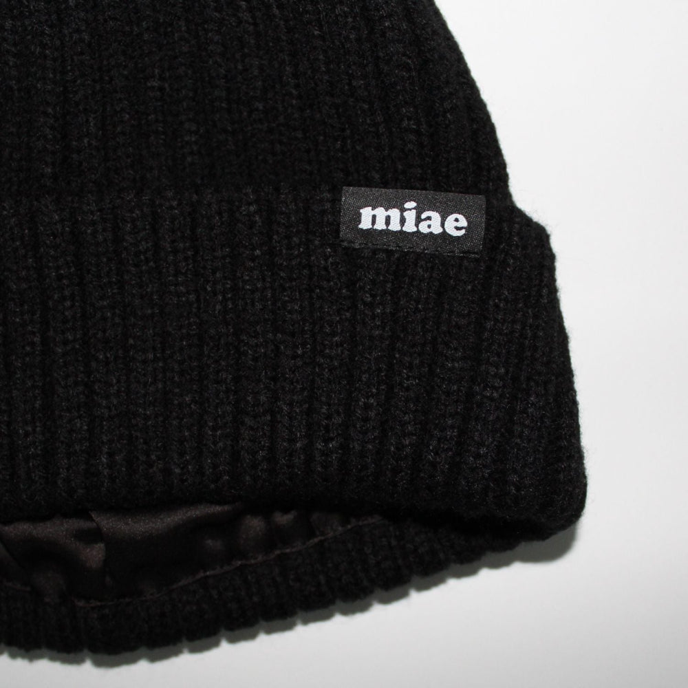 Close-up of the Miae Satin-Lined Beanie in Black, revealing the silky satin lining that helps protect natural, textured, and curly hair from frizz and dryness
