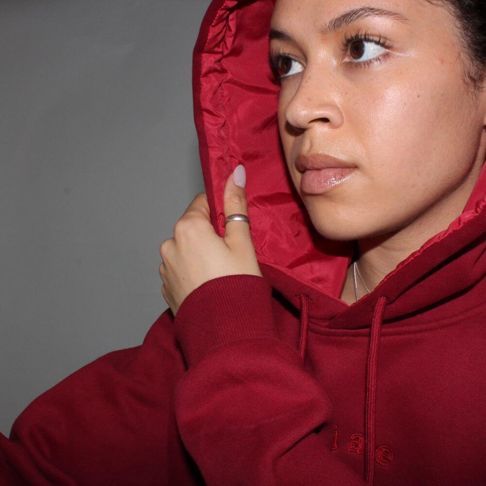 Model showing the satin-lined inside of the Miae Maroon Hoodie, with a focus on the frizz-reducing fabric for textured and curly hair.