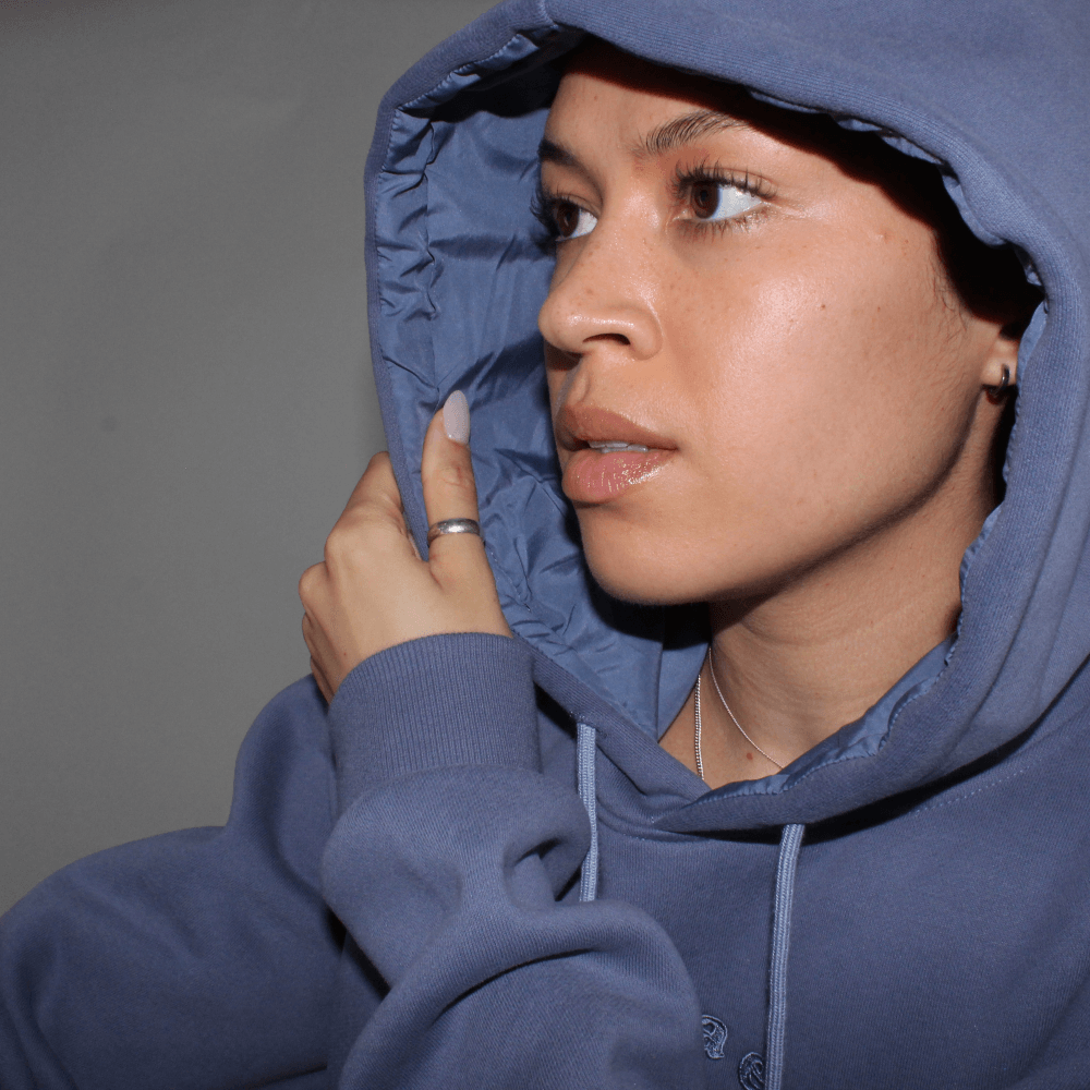 Model showing the satin-lined inside of the Miae Washed Blue Hoodie, emphasizing the frizz-reducing, moisture-locking fabric.