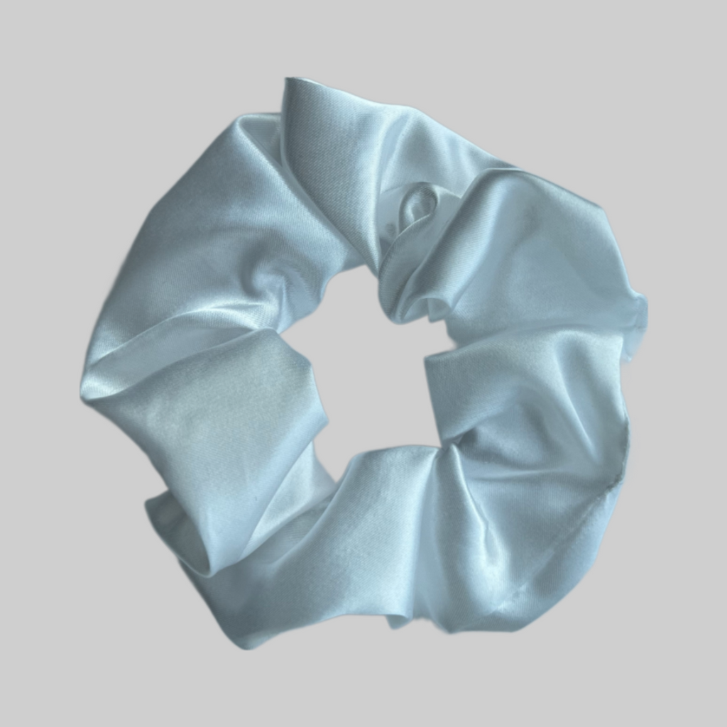Flat lay of the Miae White Satin Scrunchie, a soft and elegant hair accessory designed to protect against frizz and breakage.